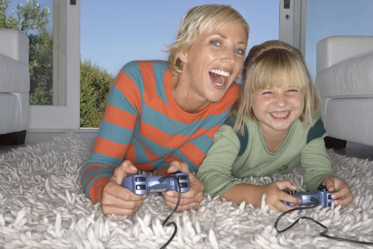 Mother and Daughter Enjoying a Video Game --- Image by © Royalty-Free/Corbis