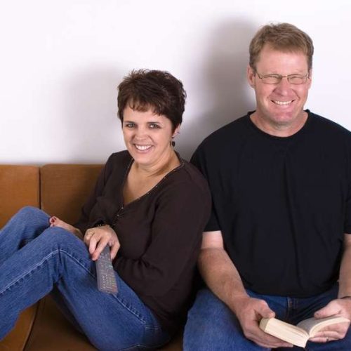 Smiling couple relaxing together on a vintage sofa.